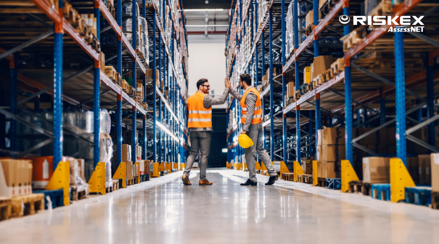 Two businessmen giving high five in a warehouse