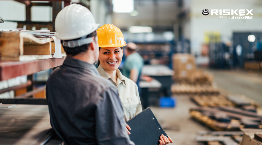 two workers talking in a factory.