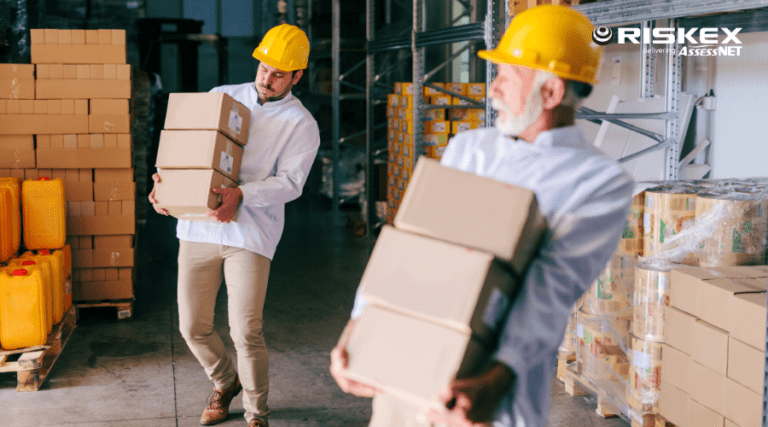 two men carrying boxes wearing hard hats.