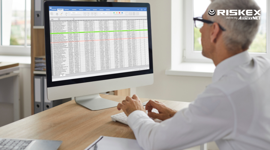 man at a computer with a spreadsheet open on a screen with a an error message popup.