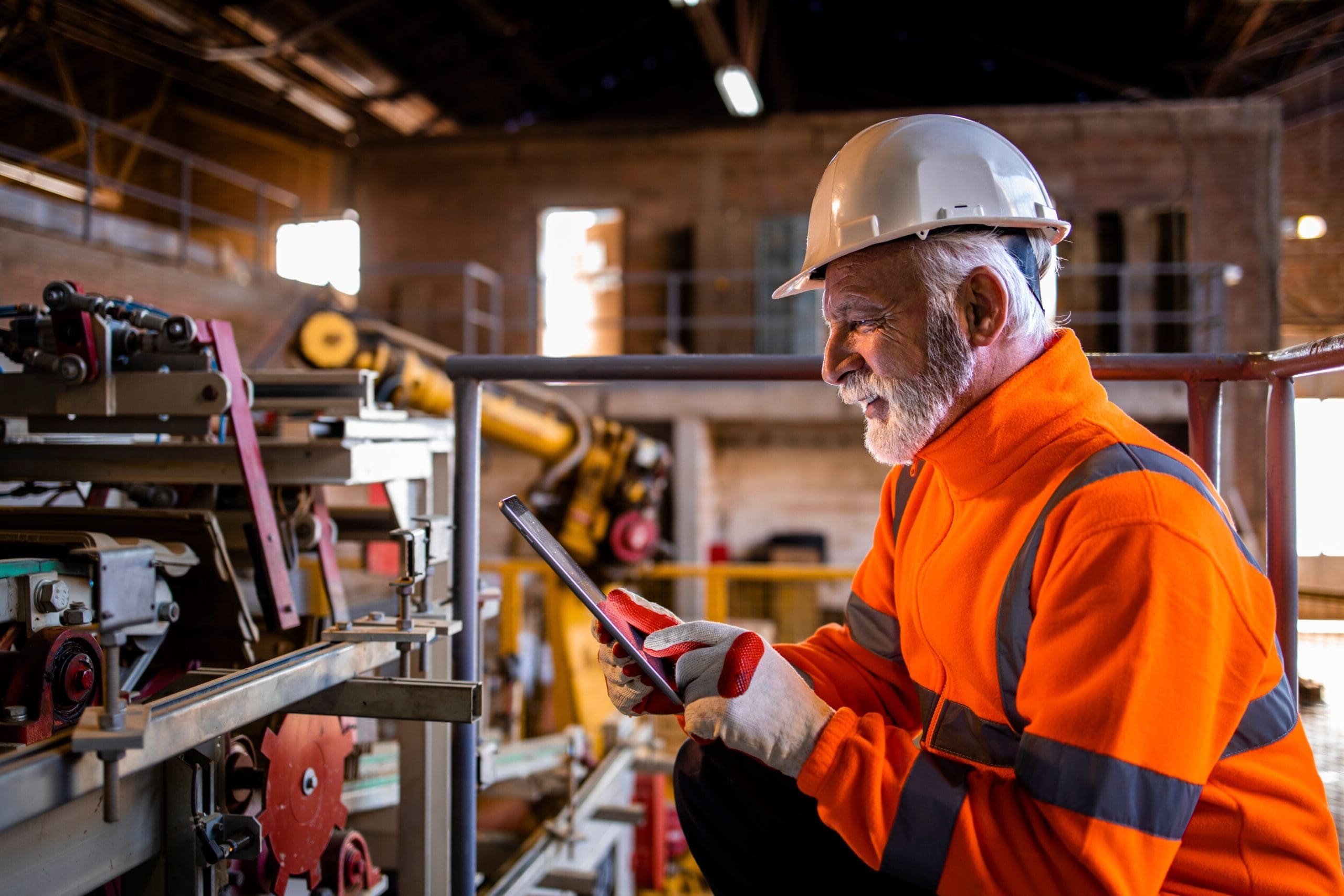 Industrial engineer or technician wearing safety equipment using a tablet.
