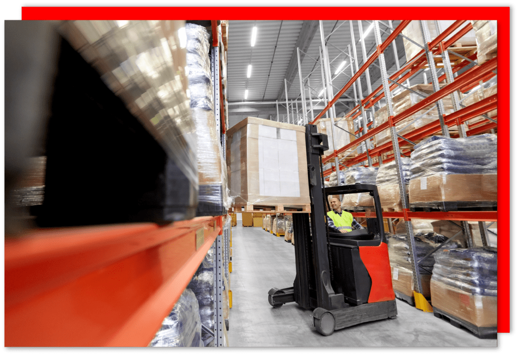 A loader operating forklift with cargo at warehouse.