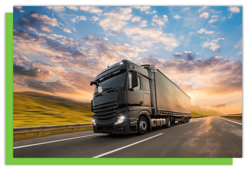 A lorry driving on a main road with a sunset behind.