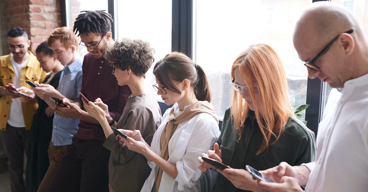 A group of young people on their phones.