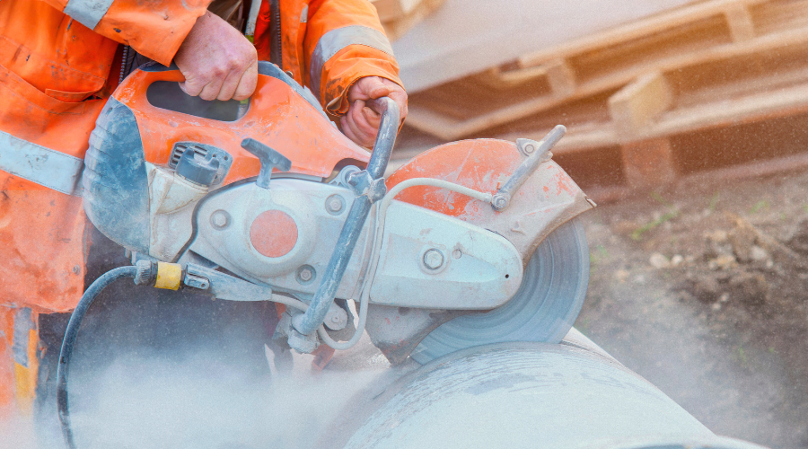 Cutting a pipe with dust in the air