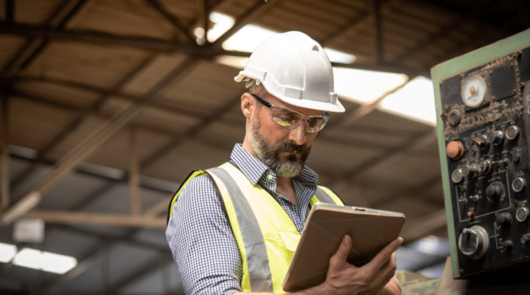 Male Engineer or Technician in Safety Uniform Working and Checking the Maintenance Information Online Data of the Machine in the Tablet.