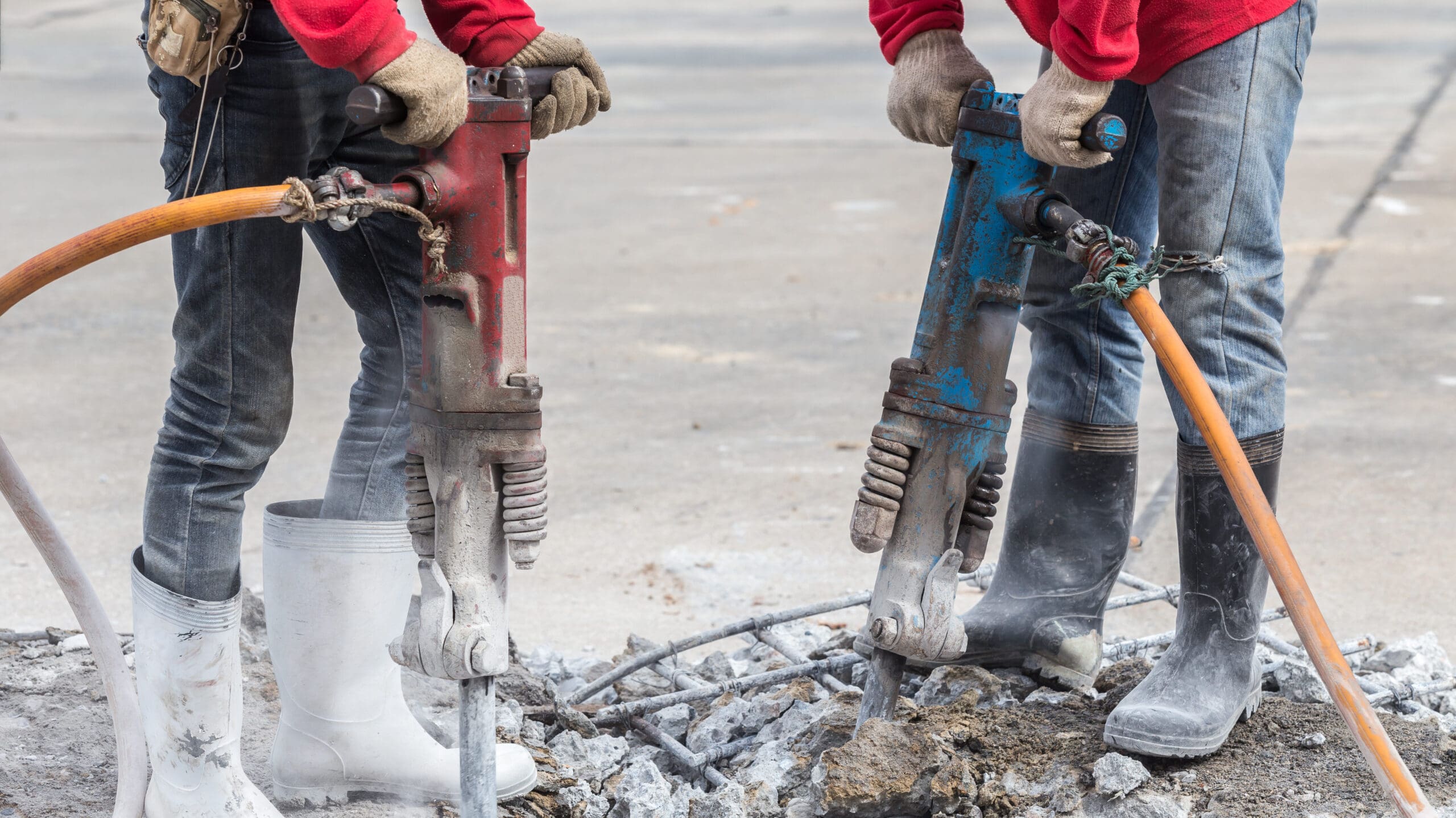 Two workers using jackhammers. 