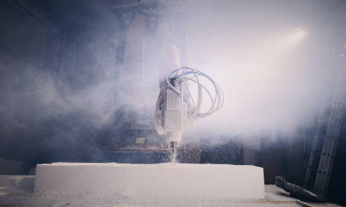 A machine cutting a material which is causing a lot of dust in the air.