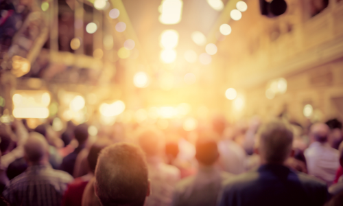 A blurred view of a crowd of people in a venue.