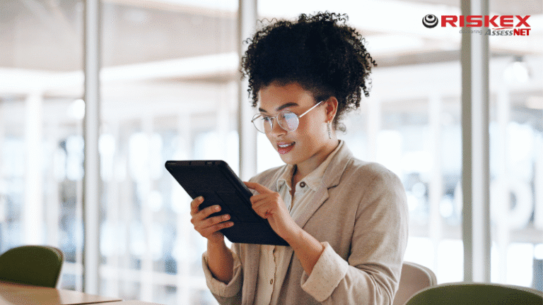 A lady sitting down in an office filling out a form on a tablet.
