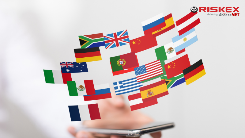 a hand holding a mobile phone with a variety of country flags hovering above.