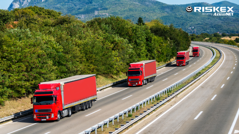 a group of red lorries on a motorway.