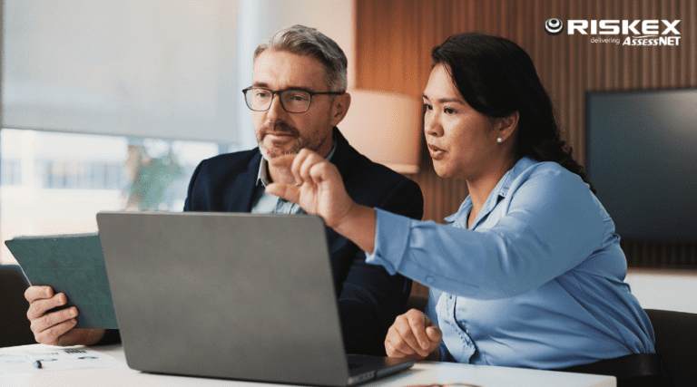 A manager and employee reviewing work together.